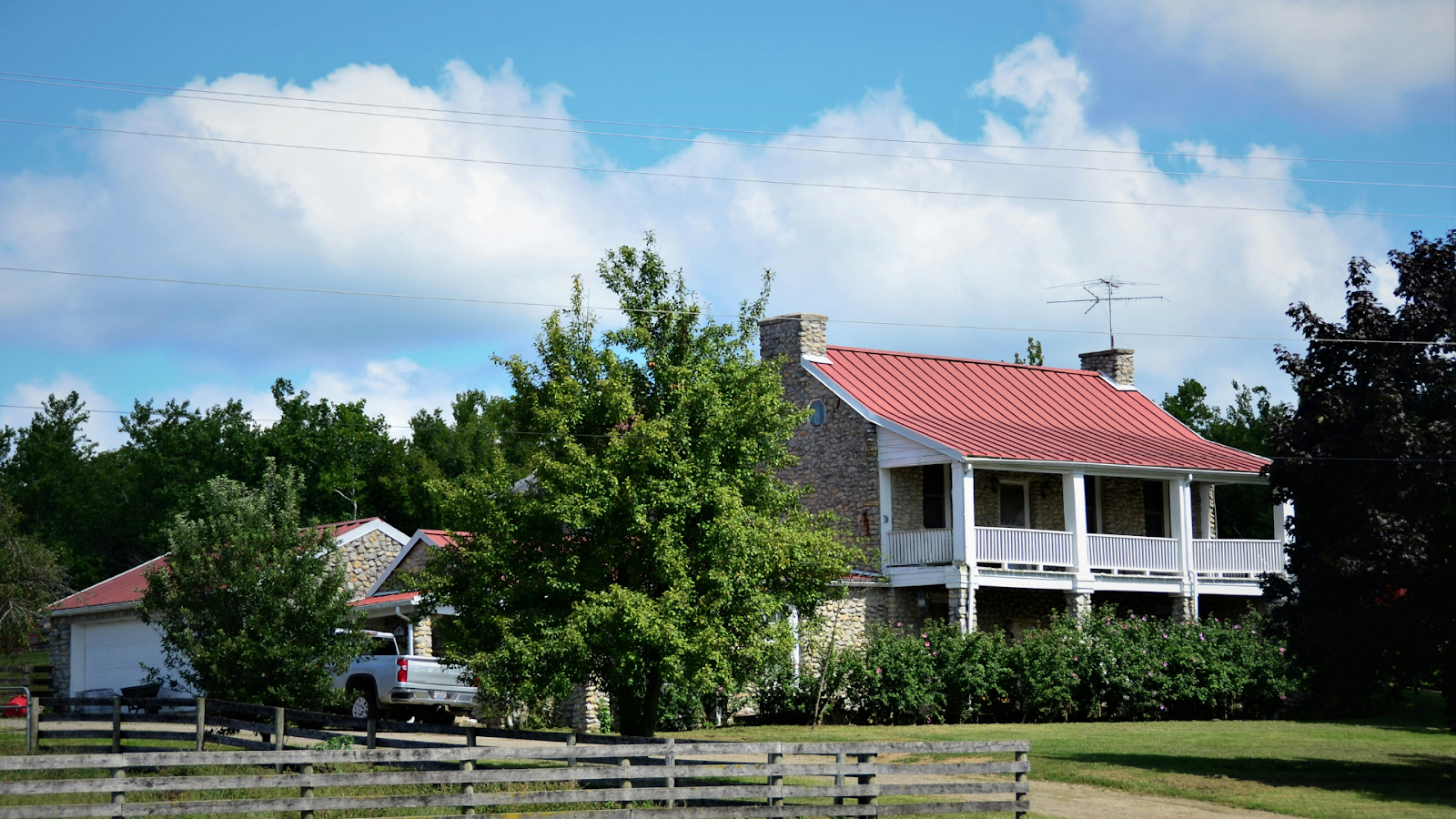 Two-story brick home with a balcony supported by white beams