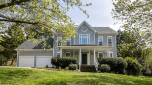 Gray three-story home with two-car garage and front porch
