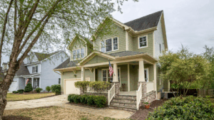 Olive-colored house with an American flag at the porch