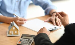 A homeowners signing documents after reading an article by Texas Tax Protest: "Do You Qualify for a Property Tax Protest? Here’s What You Need to Know"