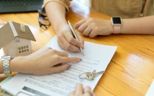 Two pairs if hands signing a document after reading "Why Hire a Professional to Help Protest Your Texas Property Taxes?" by Texas Tax Protest.