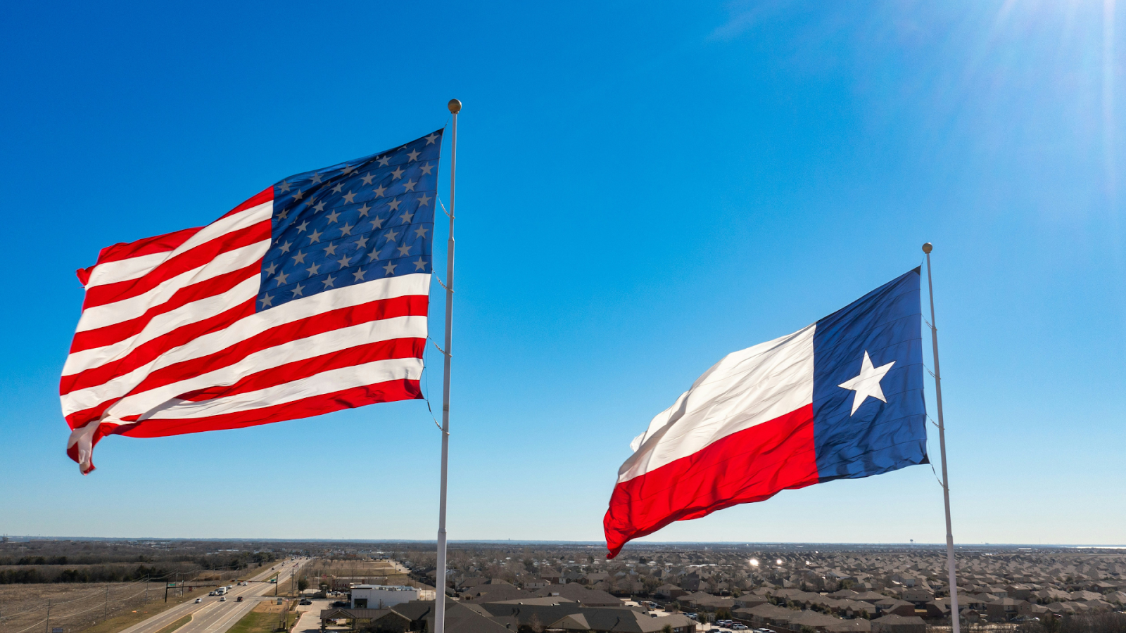 American and Texas state flags swaying in the wind
