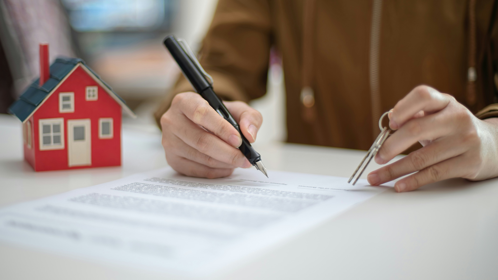 Person reviewing a contract with a key in hand