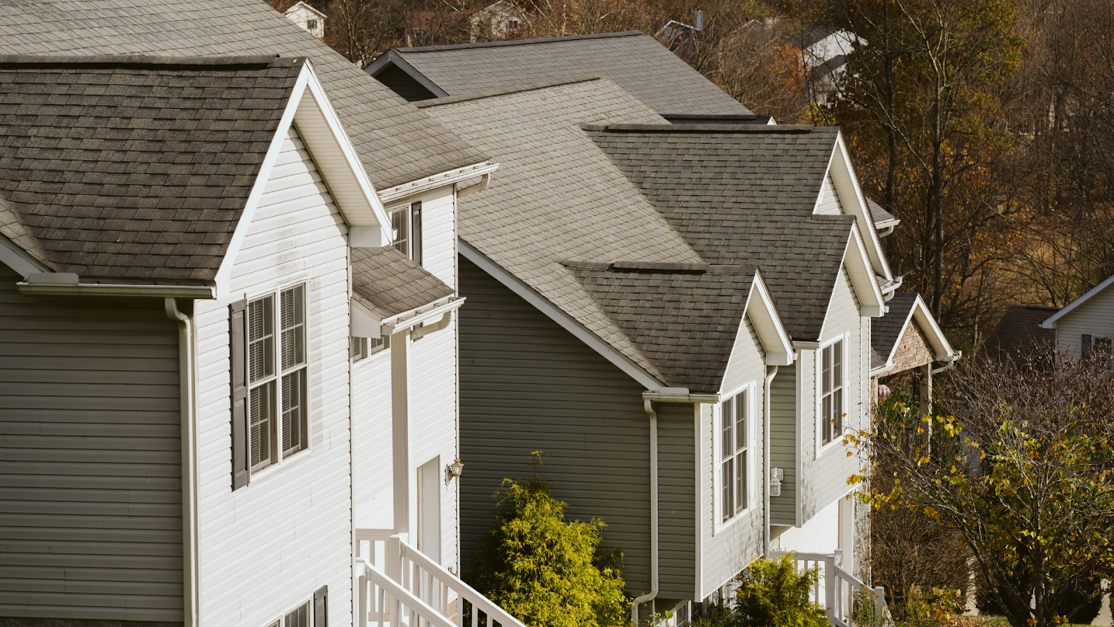 Row of gray homes with white trimming on a suburban road