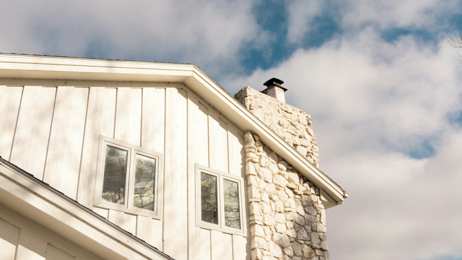 Wooden home with a white stone chimney and white trimmings